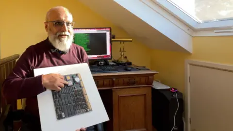 Computer Engineer Shaheed Haque holds the first circuit board he designed for the company after joining them in the nineteen eighties.