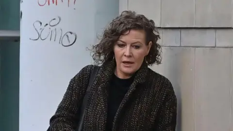 Pacemaker Fiona Donohoe outside court, walking in. She has short dark curly hair and is wearing a black top and a wool coat.