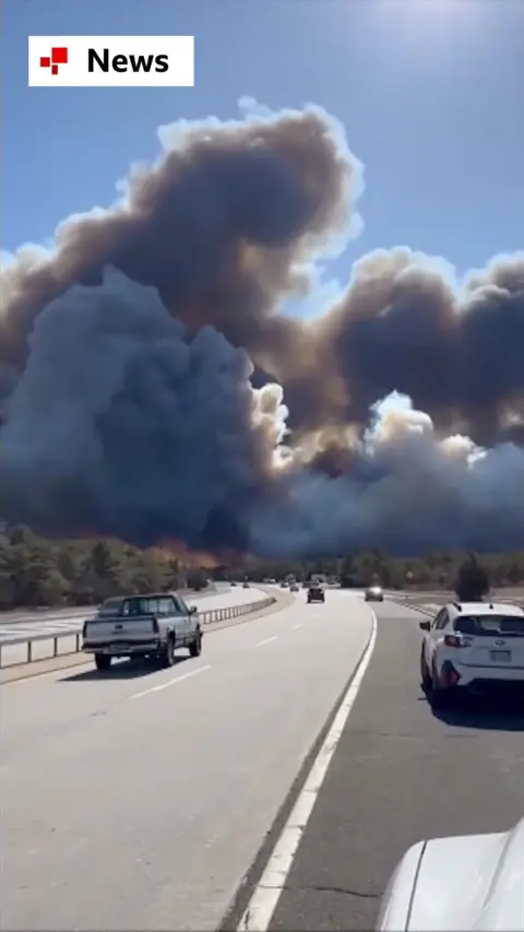 Thick black smoke looms over a New York motorway