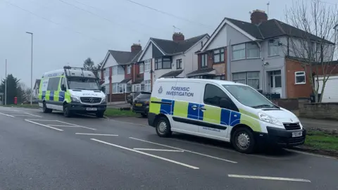 Police vehicles outside a house in Broad Avenue in Leicester