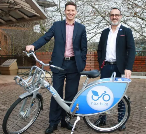 Cardiff Council Councillor Caro Wild (left) and Julian Scriven, from Nextbike UK, with one of the bikes