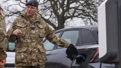 British Army Soldier charging an electric car