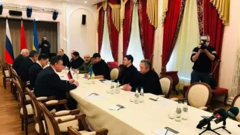 Getty Images Ukraine and Russian officials sit on opposite sides of a table