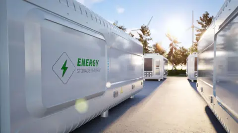 Getty Images A computer generated image of an energy storage plant with large container sized units and wind turbines in the background
