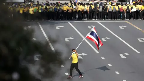Reuters A royalist carries a flag of Thailand as pro-democracy demonstrators stage a Thai anti-government mass protest, on the 47th anniversary of the 1973 student uprising, in Bangkok, Thailand October 14,