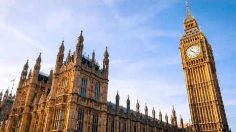 Exterior view of the Houses of Parliament and Big Ben, photographed under a bright blue sky