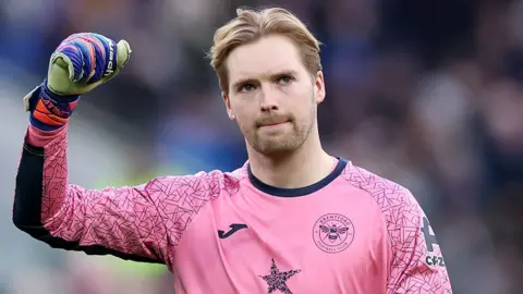 Brentford goalkeeper Caoimhin Kelleher salutes fans during a Premier League match 