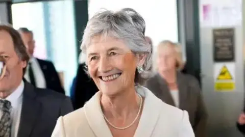 Catherine Connolly has short grey hair and is wearing a cream blazer. 