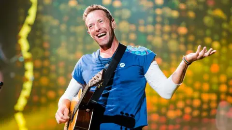 酷玩樂團 (Coldplay) 的克里斯馬汀 (Chris Martin) 於 2017 年 11 月 7 日在巴西聖保羅安聯公園舞台上現場表演