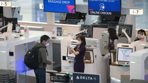 Lightrocket/Getty Images man checks in at Haneda Airport in Tokyo