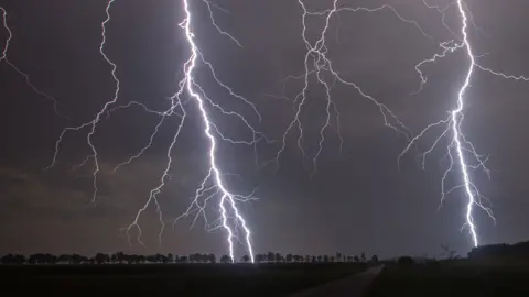 Lightening striking in dark in countryside