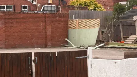Close-up of the fences and Partou Sunny Days Nursery and Pre-school's playground showing damage to fencing at the rear after a car crashed through them. The nursery is on Vale Road, Whitby, Ellesmere Port.