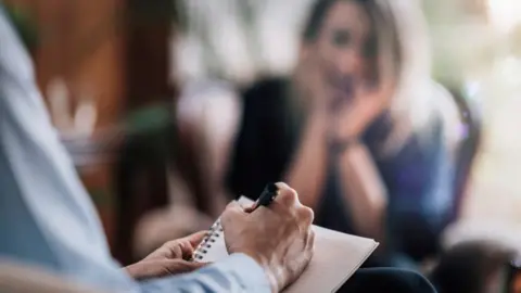 Blurred picture of a doctor taking notes during meeting with a patient