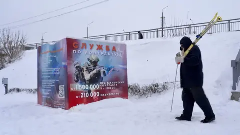A recruitment poster in the Russian town of Yelets promises big sums of money for anyone who joins up. It shows a man in uniform pointing a rifle to the right