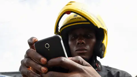 AFP A motorbike taxi rider in Nigeria