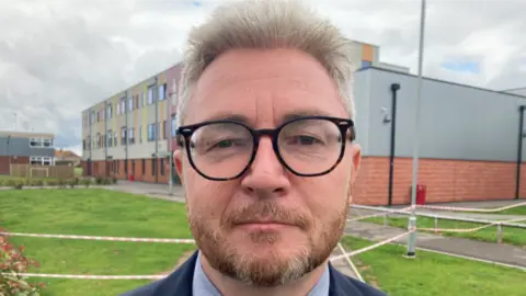 A man standing in a school field