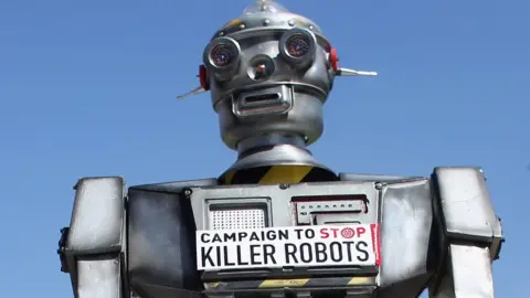 Getty Images A robot distributes promotional literature calling for a ban on fully autonomous weapons in Parliament Square, London, 23 April 2013