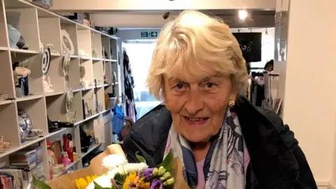 A photo of Beatrice Corry holding some flowers