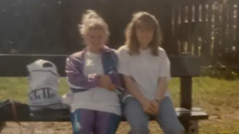 Supplied An old grainy photo showing two teenage girls sitting on a bench with a bag next to them.