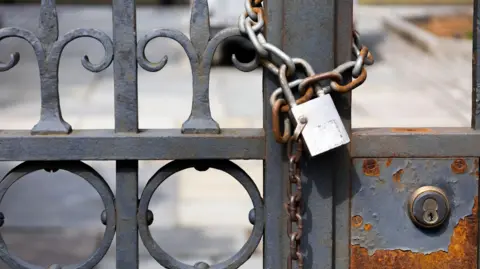 Getty Images A locked iron gate with a padlock around it