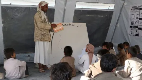 Getty Images Yemeni students study in a tent after their school was damaged in fighting in the northern province of Saada