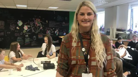 Teacher Penny Pearson with artistic drawings of a heart behind her