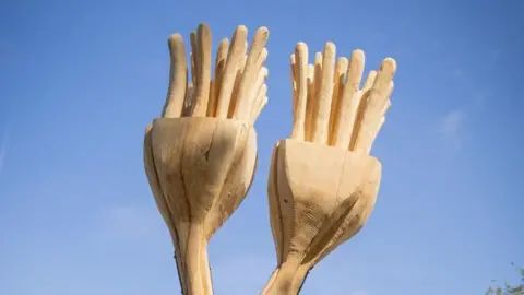 Leicestershire County Council The wooden carved fronds of the fossil against a blue sky