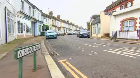 The corner of a residential street with a sign reading 'Windsor Road'