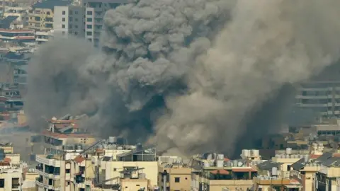 Smoke rises above Beirut's southern suburbs during an Israeli strike.