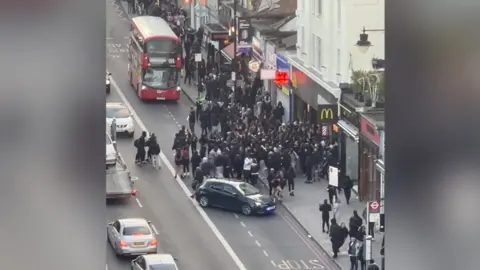 Screenshot of film showing a large gathering on the road