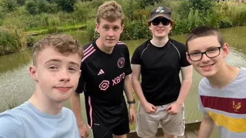 Born in Bradford Four teenage boys posing for a photo in front of a river