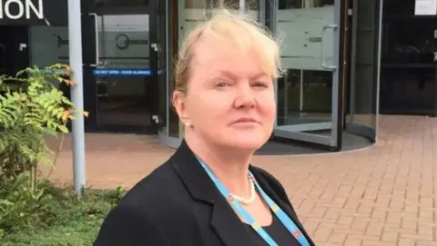 Coroner Yvonne Blake in a black jacket outside a building with a set of revolving doors.