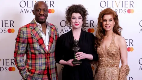 PA Media Isobel McArthur (centre) in the Oliviers press room with presenters Giles Terera (left) and Cassidy Janson