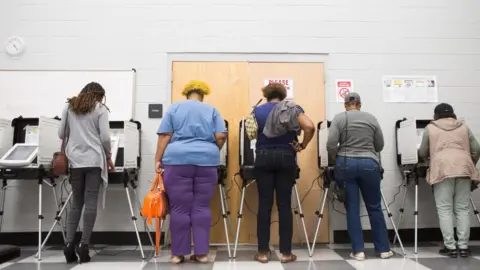 Getty Images Georgia voters cast a ballot at the polls as part of the state's early voting initiative.