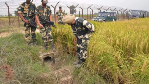 Getty Images Police inspecting a pipe used by smugglers