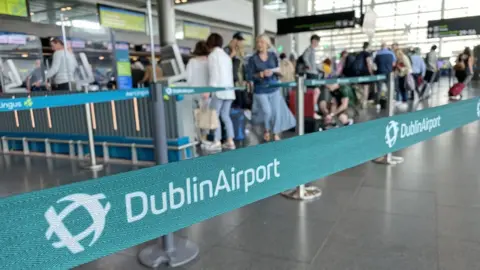 Dominic McGrath/PA Wire People queuing inside Dublin Airport on Thursday morning