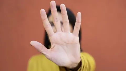 Getty Images Woman holding hand up