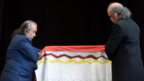Getty Images Neville Reys (L) and Hendrick Fourmile (R) of the Gimuy Walubara Yidindji people, prepare the coffin with the remains of an Australian aboriginal in Munich