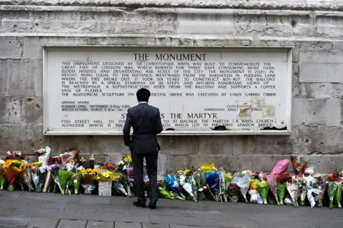 Reuters A man observes flowers left along the base of the Monument to the Great Fire of London