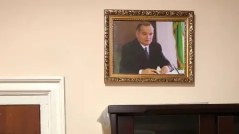 A photo of former Uzbek President Islam Karimov hangs on a off-white wall in a Uzbek hospital