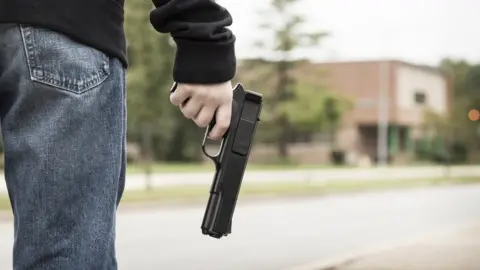 Getty Images Person with gun