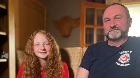 BBC A photo of Heather Bryson sitting next to her father Gary Bryson who spoke to the BBC about social media and smartphone use by children