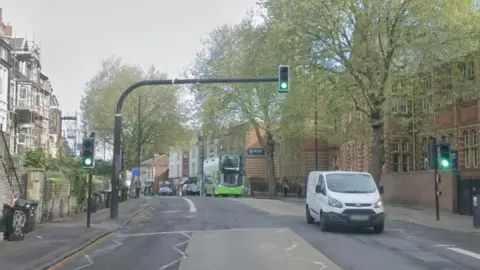 Google Maps street view of Cheltenham Road in Bristol. There are traffic lights and buildings either side of the road. Vehicles can be seen driving along.