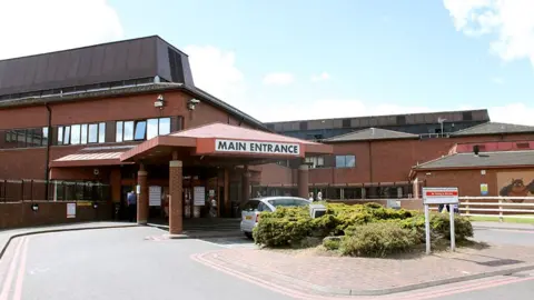 The main entrance to Lincoln County Hospital, which is a brown brick two-storey building with a canopy over the main entrance.
