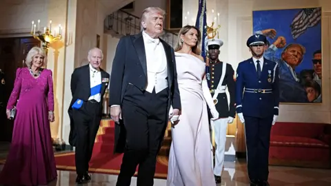Queen Camilla, King Charles III, U.S. President Donald Trump, and First Lady Melania Trump pose at the base of the Grand Staircase during an official state dinner hosted by the President and First Lady at The White House on day two of the State Visit