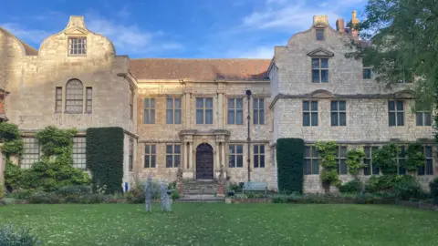 BBC/Julia Lewis A picture of York's Treasurer's House in sunshine, a Grade I listed building with light stone walls and a neat garden in the front