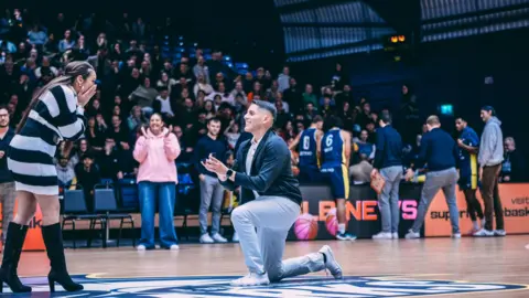 Carlo Vidal Miranda bends down on one knee proposing to his girlfriend, Dianelis Feria-Menes.