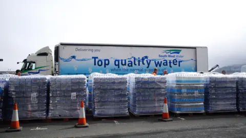 PA Media A lorry with pallets of water bottles
