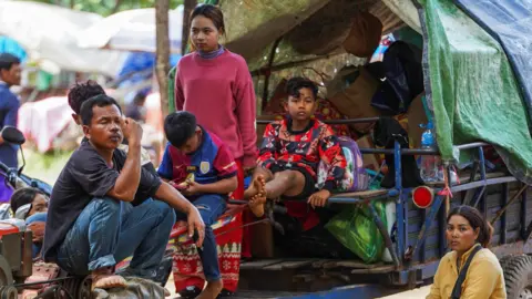 People, evacuating from Pong Tuek village, in Banthey Empel district, around 20 km (12 miles) from the disputed Ta Moan Thom temple, rest at a temporary shelter