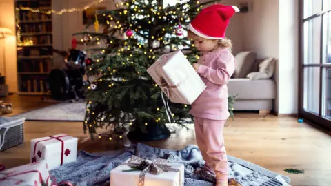 Getty Images Child opens Christmas presents